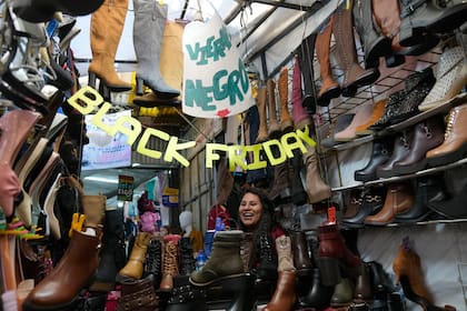 Una vendedora de zapatos espera la llegada de clientes en el mercado de Uyustos en el Viernes Negro en La Paz, en Bolivia, el viernes 25 de noviembre de 2022. (AP Foto/Juan Karita)