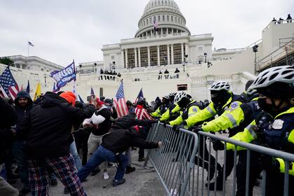 Una violenta turba trumpista rompe una barrera policial durante la toma del Congreso del 6 de enero del 2021. (AP Photo/Julio Cortez, File)