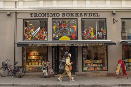 Una violonchelista pasa junto a Tronsmo, la librería independiente más antigua de la ciudad con una gran selección de cómics y libros en otros idiomas.