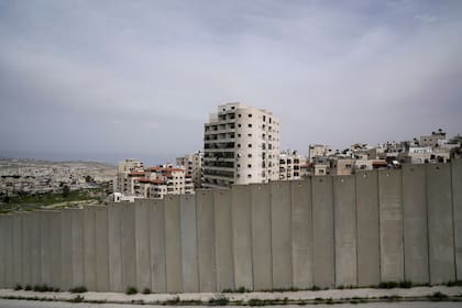 Una vista del campo de refugiados de Shuafat se ve tras una parte de la barrera de separación en Jerusalén el domingo 17 de marzo de 2024. Rami Halhouli, de 12 años, murió baleado por un policía israelí cuando lanzaba fuegos artificiales el 12 de marzo. (AP Foto/Mahmoud Illean)