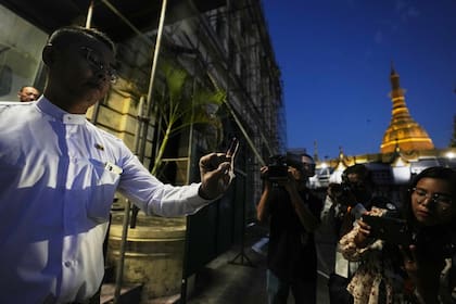 Una votante muestra su dedo marcado con tinta, lo que indica que ha votado, al salir de un centro de votación, en Rangún