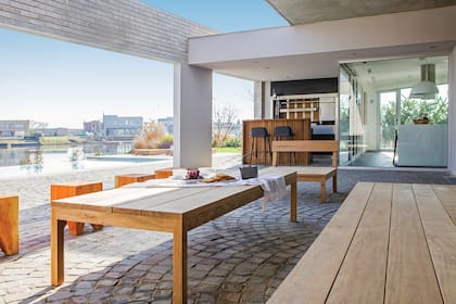 Una zona de estar con mesa baja, sillón de tres cuerpos y bancos ‘Muelita’, todo de Las Marinas.