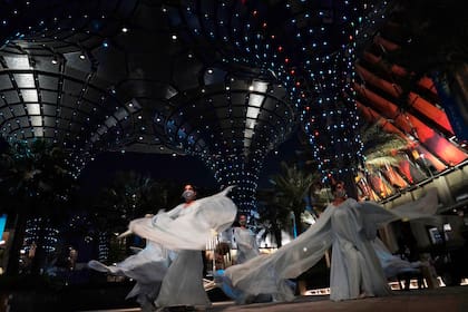 Unas bailarinas actúan en el marco de la Expo 2020 en Dubái, Emiratos Árabes Unidos, el lunes 18 de octubre de 2021. (AP Foto/Jon Gambrell)