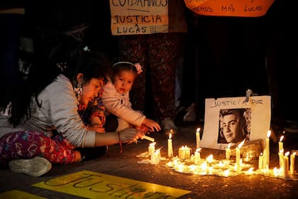 Unas niñas prenden unas velas en homenaje a Lucas en el barrio Naval