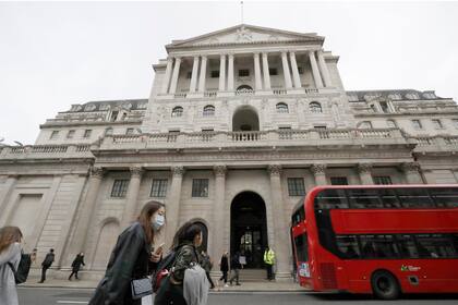 Unas personas caminan frente al Banco de Inglaterra el 11 de marzo de 2020 en Londres. (AP Foto/Matt Dunham, FILE)