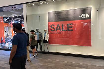 Unas personas pasan frente a un cartel que anuncia ofertas en un centro comercial el miércoles 11 de septiembre de 2024 en Lakewood, Colorado. (Foto AP/David Zalubowski, Archivo)