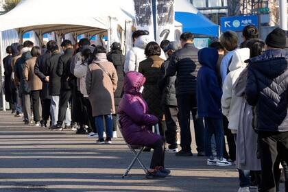 Unas personas se forman para someterse a una prueba de coronavirus en Seúl, el miércoles 8 de diciembre de 2021. (AP Foto/Ahn Young-joon).