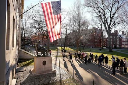 Unas personas toman fotos a la estatua de John Harvard, en la Universidad de Harvard