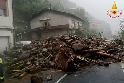 Unas ramas y rocas yacen sobre el asfalto luego de que un alud azotó una localidad cercana al lago de Como, en Italia, el martes 27 de julio de 2021. (Vigili del Fuoco vía AP)