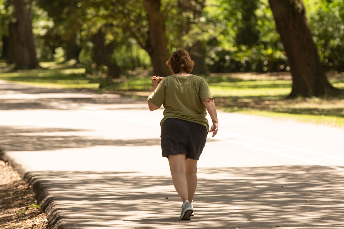 unknown obese woman is making progress walking in the park