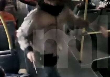 Uno de los asaltantes amenaza con un cuchillo al pasajero