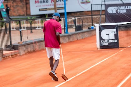 Uno de los cancheros del Challenger de Kigali, en la capital de Ruanda, barriendo los flejes; tres argentinos actúan en el torneo inédito en el país africano