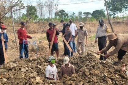 Uno de los castigados cava una tumba para una víctima de Covid-19