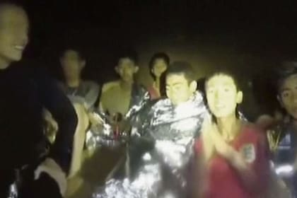 Uno de los chicos atrapados en la cueva saluda a los rescatistas al ser hallado el grupo