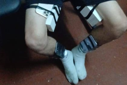 Uno de los delincuentes con los celulares pegados en su cuerpo cuando intentaba escapar