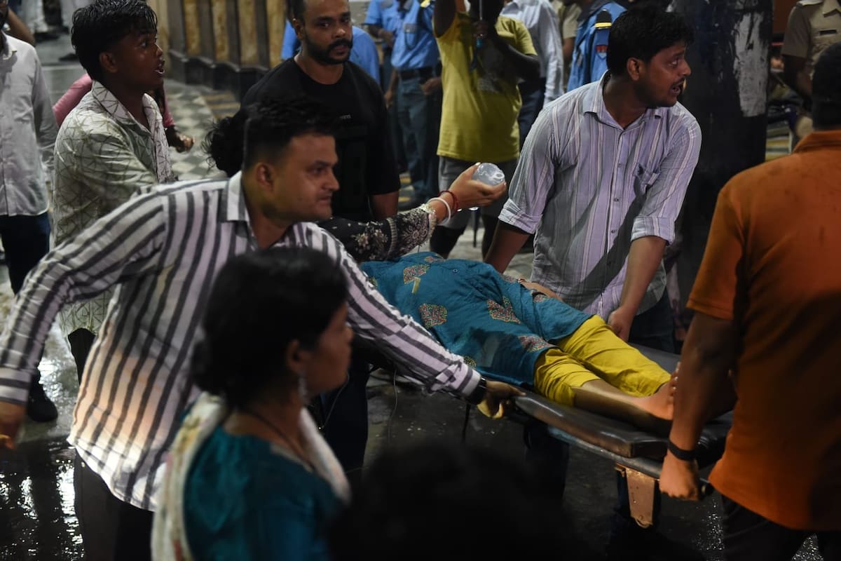 Uno de los heridos es trasladado por los presentes durante el festejo por el “Durga Puja"