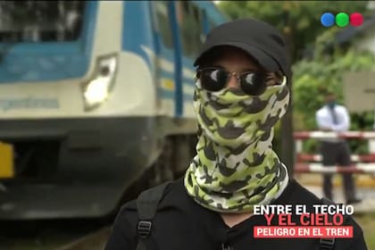 Uno de los jóvenes que se trepa al tren