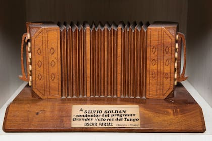 Uno de los tantos regalos que atesora de sus años como conductor de Grandes valores del tango: un bandoneón con su nombre grabado.