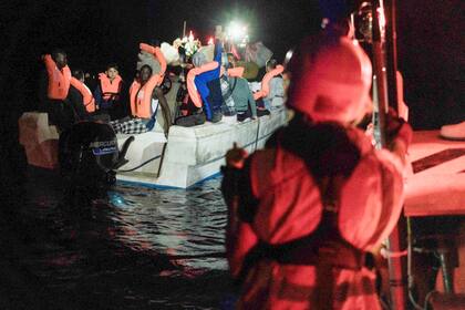 Unos 35 migrantes, incluidos tres niños, en su mayoría de Siria, permanecen sentados en una lancha en aguas internacionales frente a Malta mientras se acerca a recogerlos el barco de rescate Ocean Viking, a primeras horas del sábado 22 de octubre de 2022. (AP Foto/Vincenzo Circosta)