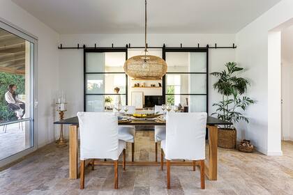 Para el interiorismo de la planta baja se buscaron piezas con materiales nobles o acabados neutros, como la lámpara (Compañía Nativa) y las sillas del comedor (Lacroze Studio), hechas en madera con fundas lavables.