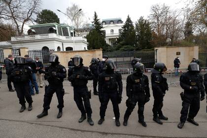 Unos policías con equipo antimotines vigilan la zona aledaña a la embajada de Rusia en Praga, República Checa, el domingo 18 de abril de 2021. (AP Foto/Petr David Josek)