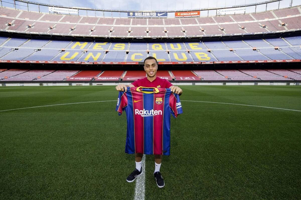 US defender Sergino Dest poses with his new team FC Barcelonas jersey, at the Camp Nou stadium in Barcelona.