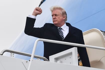 El expresidente Donald Trump hace gestos antes de abordar en el avión presidencial Air Force One, en Maryland, enero 12, 2018