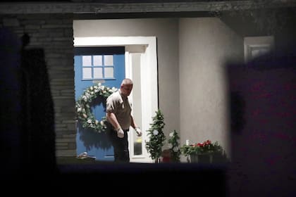 Un agente de seguridad se encuentra cerca de la puerta principal de la casa de Enoch, Utah, donde ocho miembros de la familia fueron encontrados muertos por heridas de bala, el miércoles 4 de enero de 2023