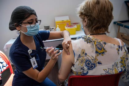 Una trabajadora de la salud administra una dosis de la vacuna Coronavac a una mujer en un centro de vacunación en el Parque Bicentenario, en Santiago, Chile, el 10 de febrero de 2021