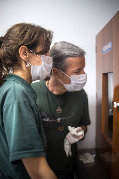 Vanesa Astore y Luis Jacome observan el nacimiento de un pichón dentro de la incubadora.