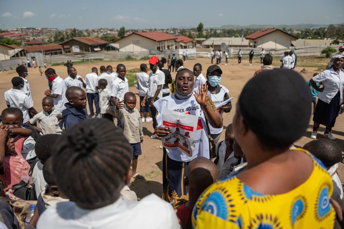 Vanny Birungi, voluntario de la Cruz Roja, habla con la gente durante una campaña de sensibilización pública en medio del brote de ébola en Bunia, Congo, el lunes 25 de mayo de 2026