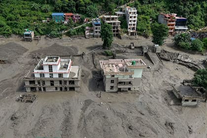 Varias casas quedaron parcialmente sumergidas en aguas fangosas junto a la ribera tras las inundaciones repentinas en Trishuli Bazar, en el distrito de Nuwakot, Nepal