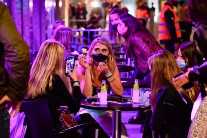 Varias mujeres toman algo en la terraza de un bar durante el ensayo clínico para una posible reapertura de los locales nocturnos, el 20 de mayo de 2021 en la localidad catalana de Sitges, al noreste de España