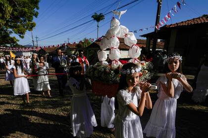 Varias niñas participan en una procesión en el festival de las Cavalhadas, el domingo 19 de mayo de 2024, en Pirenópolis, estado de Goiás, Brasil. Un sacerdote portugués trajo la tradición a Brasil en el siglo XIX para celebrar al Espíritu Santo y conmemorar la victoria de los caballeros ibéricos cristianos sobre los moros. (AP Foto/Eraldo Peres)