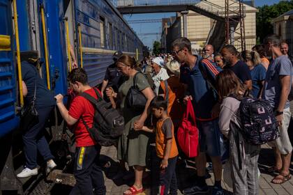 Varias personas abordan un tren el viernes 10 de junio de 2022 en la estación de Pokrovsl, en el este de Ucrania. (AP Foto/Bernat Armangue )