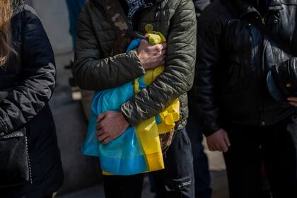 Varias personas asisten a un funeral por cuatro soldados ucranianos que murieron durante un ataque aéreo ruso a una base militar en Yavoriv, en una iglesia en Leópolis, Ucrania, el 15 de marzo de 2022. (AP Foto/Bernat Armangué)
