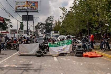 Varias personas bloquean la Carretera Panamericana el viernes 13 de octubre de 2023, en San Lucas Sacatepéquez, Guatemala, para exigir la renuncia de la fiscal general Consuelo Porras. (AP Foto/Santiago Billy)