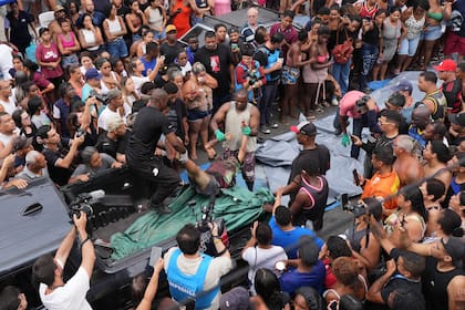 Varias personas cargan en una camioneta los cuerpos de las personas muertas durante la redada