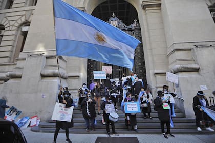 Varias personas celebran el fallo de la Corte a favor de las clases presenciales en la puerta de los tribunales de la calle Talcahuano