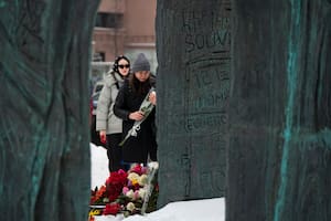 Varias personas dejan flores para honrar a Alexei Navalny en el Muro de Tristeza, un monumento para honrar a las víctimas de la represión política, en Moscú, Rusia, el sábado 17 de febrero de 2024. (AP Foto/Alexander Zemlianichenko)