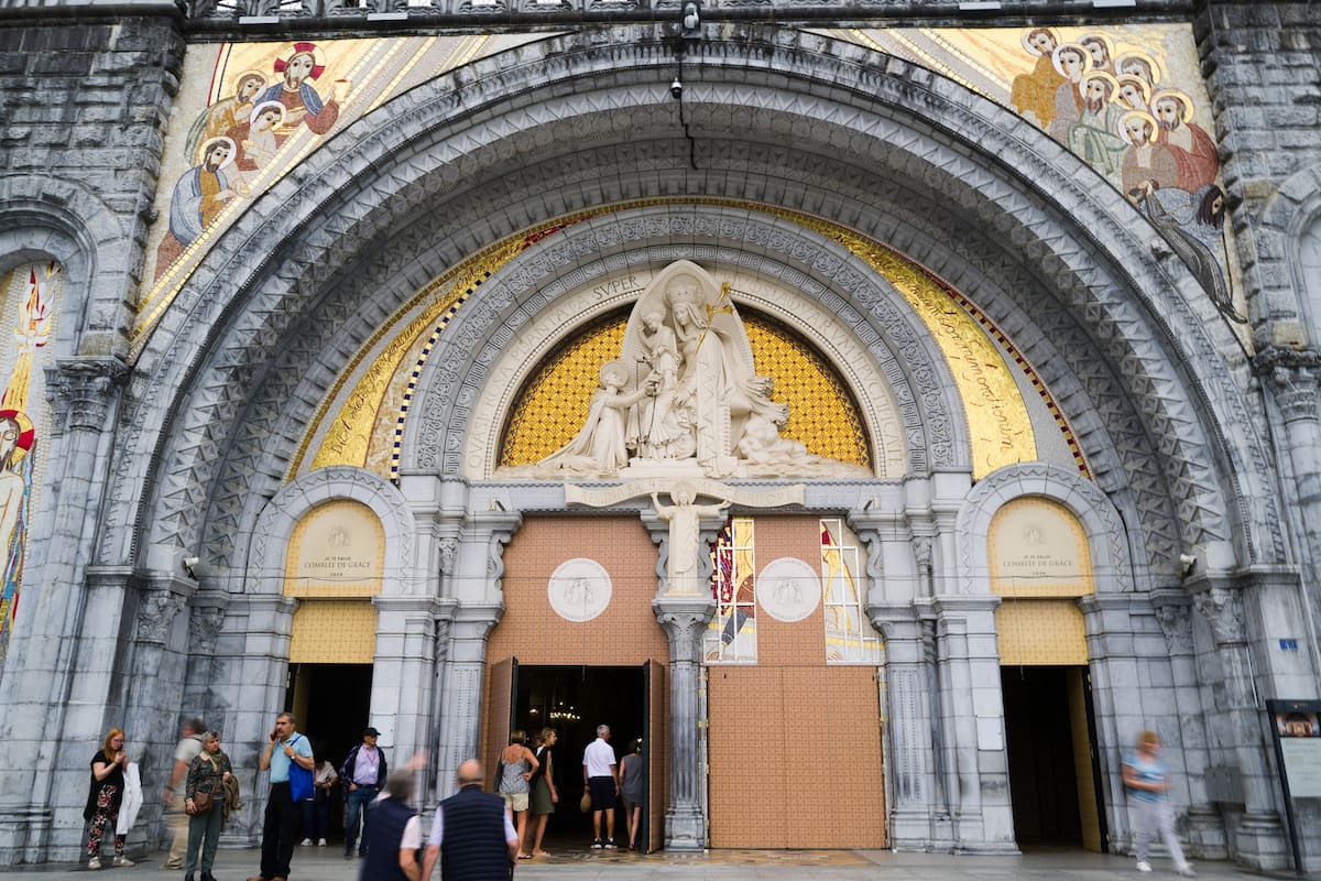 Varias personas entran en la basílica de Nuestra Señora del Rosario en Lourdes, en el suroeste de Fr