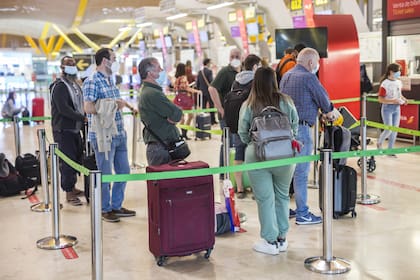 Varias personas hacen fila en la terminal T4 del Aeropuerto Adolfo Suárez Madrid-Barajas