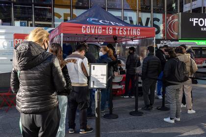 Varias personas hacen fila para que les hagan una prueba para detectar si no están contagiadas con el coronavirus en Times Square, Nueva York, el viernes 3 de diciembre de 2021. (AP Foto/Yuki Iwamura)