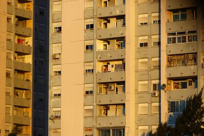 Varias personas miran desde sus ventanas o balcones en medio de la cuarentena obligatoria