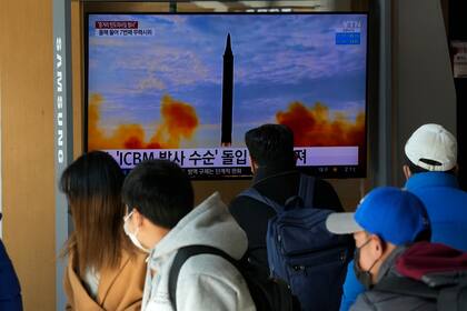 Varias personas observan el domingo 30 de enero de 2022, en Seúl, Corea del Sur, un televisor que muestra una imagen del lanzamiento de un misil por parte de Corea del Norte. (AP Foto/Ahn Young-joon)