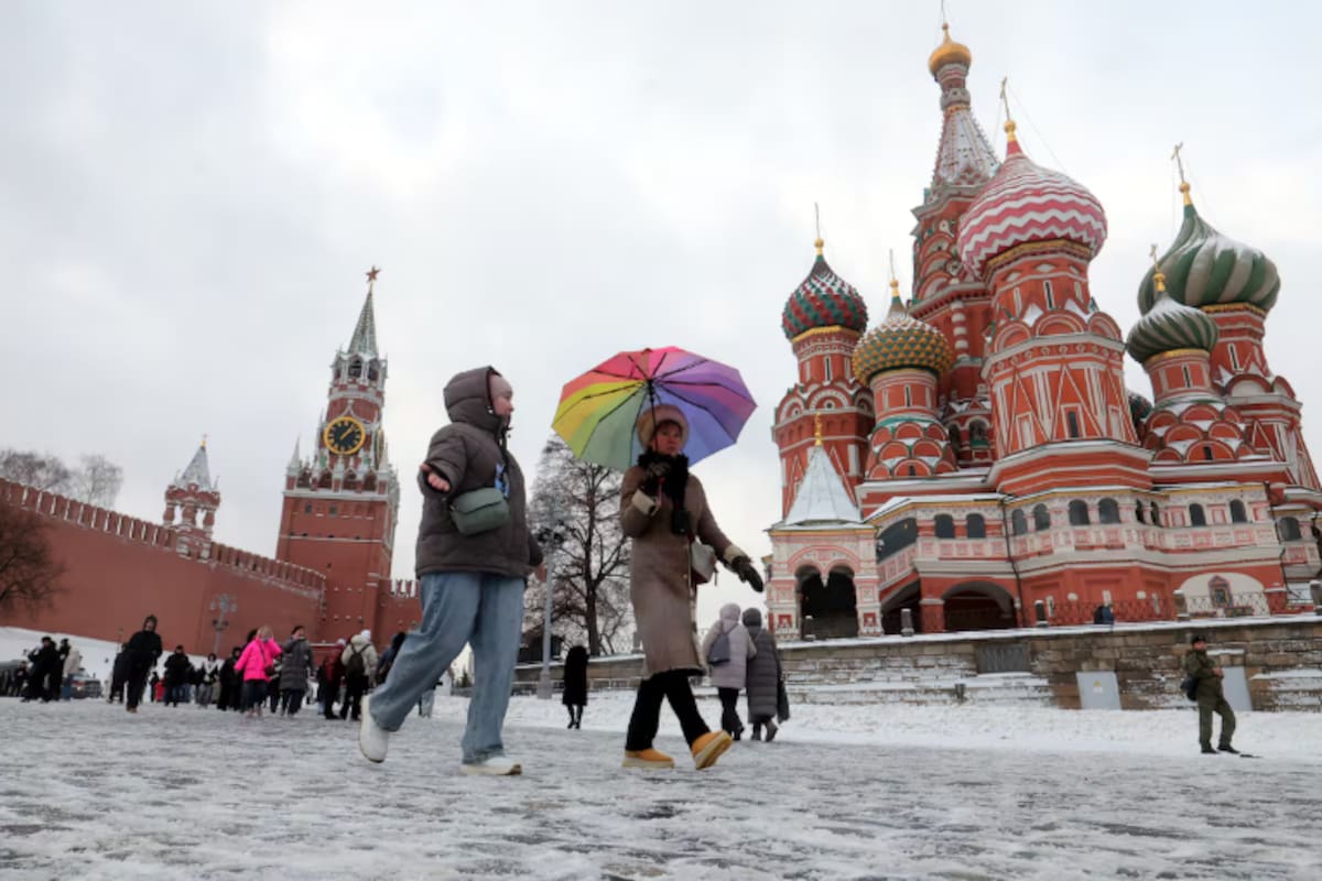 Varias personas pasean por el Kremlin, en Moscú, durante una tormenta este viernes 26 de diciembre