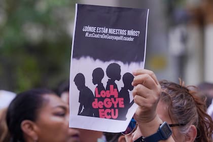 Varias personas protestan ante la sede de la fiscalía contra la desaparición de cuatro menores el pasado 8 de diciembre que huían de un convoy militar, en Guayaquil, el lunes 23 de diciembre de 2024.