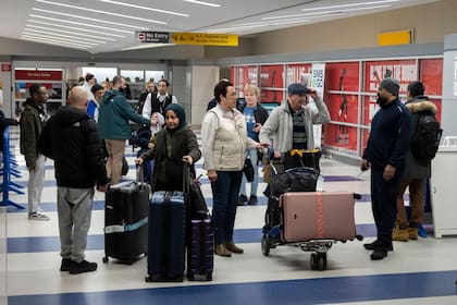 Varias personas salen de la terminal tras su llegada al Aeropuerto Internacional John F. Kennedy procedentes de Amán, Jordania, el jueves 5 de marzo de 2026. (AP Foto/Yuki Iwamura)