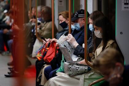 Varias personas vstiendo mascarillas para frenar la propagación del coronavirus viajan en el metro de Moscú, Rusia, el jueves 10 de junio de 2021. (AP Foto/Alexander Zemlianichenko)