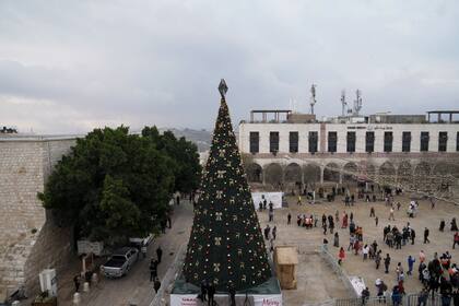 Varias se personas se reúnen el sábado 24 de diciembre en la plaza Manger, adyacente a la Iglesia de la Natividad, donde según la tradición cristiana nación Jesucristo, en la localidad de Belén, en Cisjordania.(AP Foto/Mahmoud Illean)